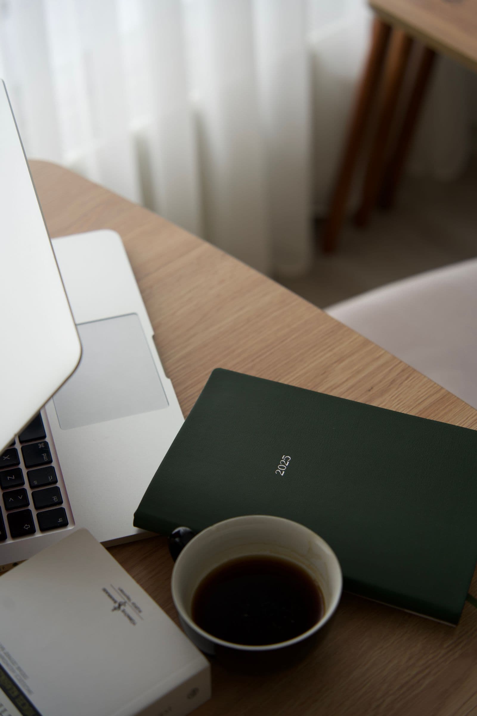 A quiet workspace with coffee, an open notebook, and warm morning light